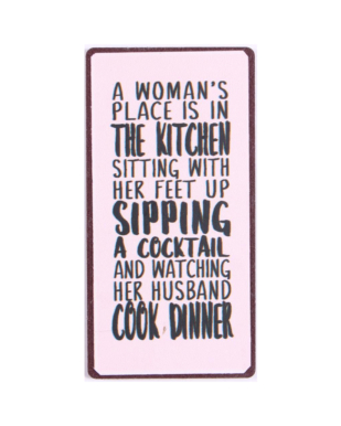 Magnet med tekst. "A woman's place is in the kitchen sitting with her feet up sipping a cocktail and watching her husband cook dinner"